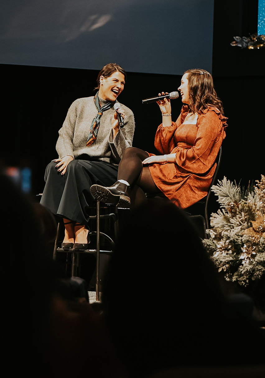 Women enjoying a conversation onstage at Christmas Desserts